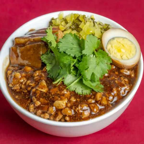 A Taiwanese braised pork rice bowl with minced pork, a hard-boiled egg, and cilantro.