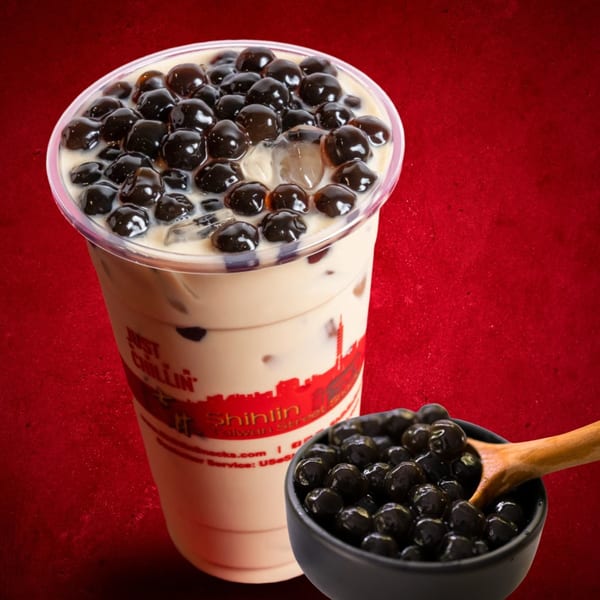 Shihlin Taiwan Street Snacks bubble tea with tapioca pearls and a bowl of pearls with a wooden spoon.