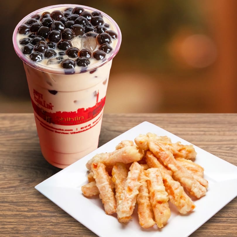 A Shihlin Taiwan Street Snacks bubble tea with dark pearls and a plate of fried Taiwanese snacks.
